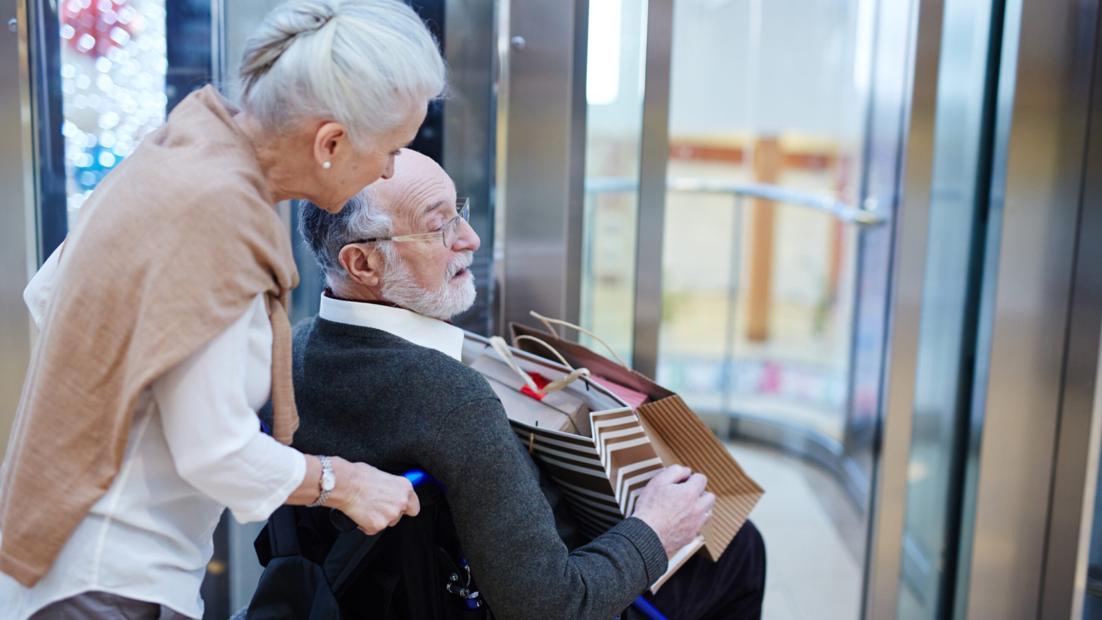Senior woman taking care of her disabled husband during shopping
