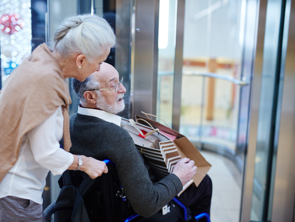 Senior woman taking care of her disabled husband during shopping